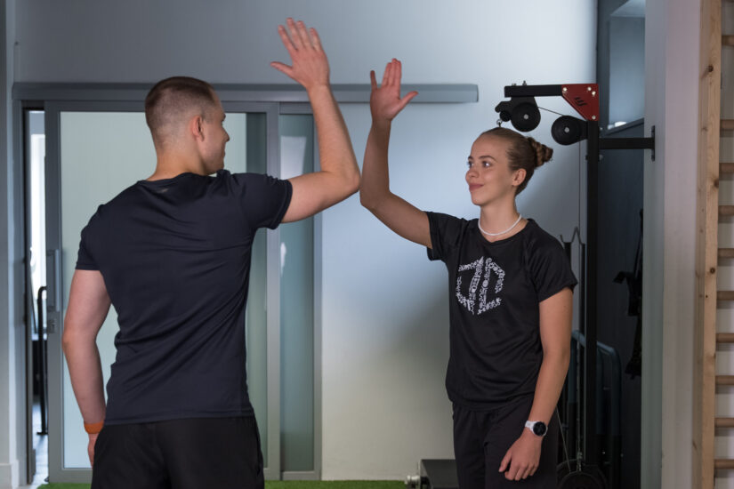 Trener Dawid Dzikiewicz podbijający piątkę z podopiecznym podczas treningu indywidualnego