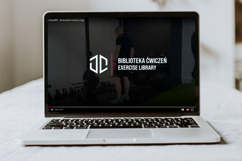 Laptop z otwartym wideo przedstawiającym bibliotekę ćwiczeń autorstwa Dawida Dzikiewicza.