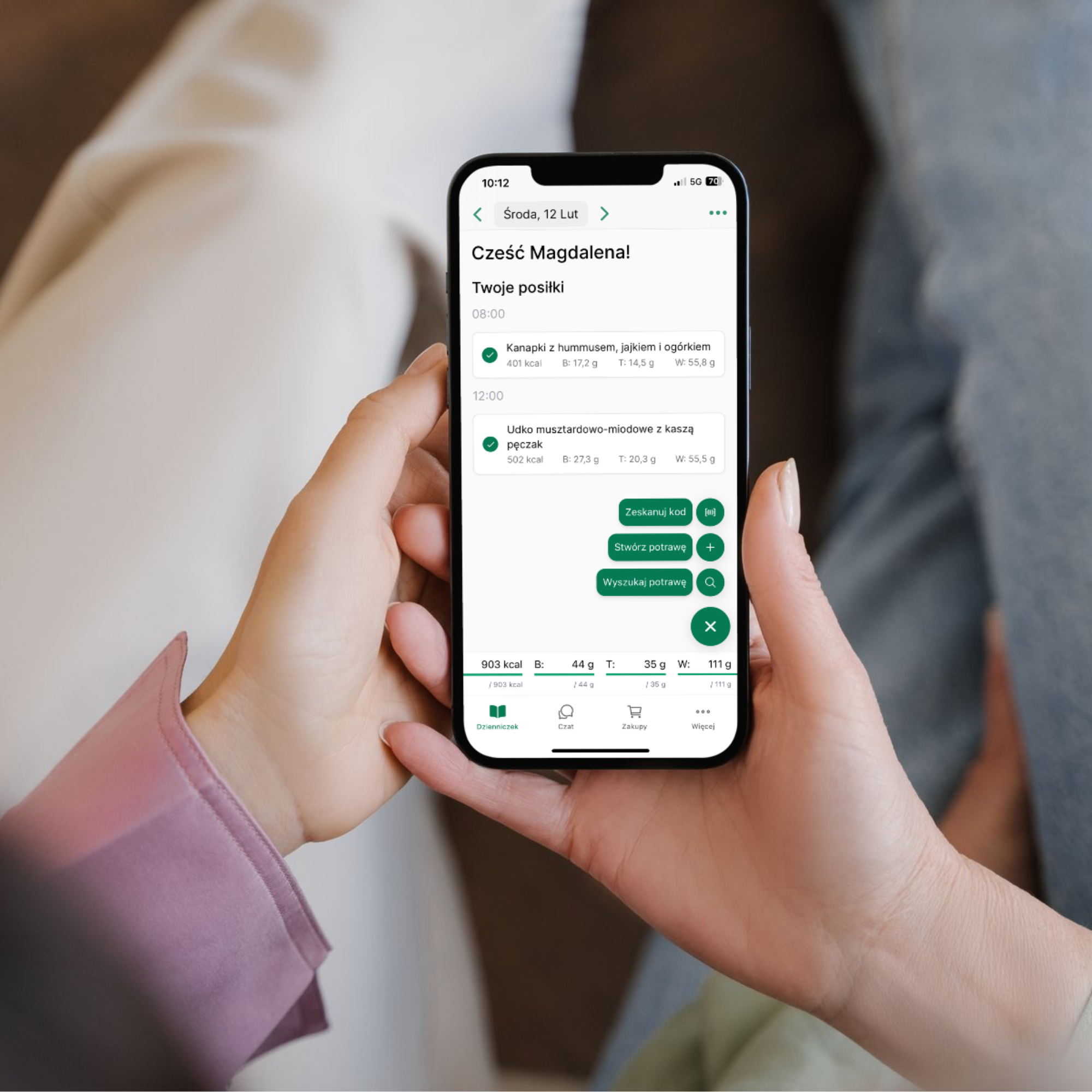 soba trzymająca smartfon z otwartą Aplikacją Żywieniową FLEX, prezentującą zaplanowane posiłki i ich wartości odżywcze.