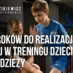 Trener pracujący z młodym sportowcem podczas ćwiczenia – realizacja celów treningowych u dzieci