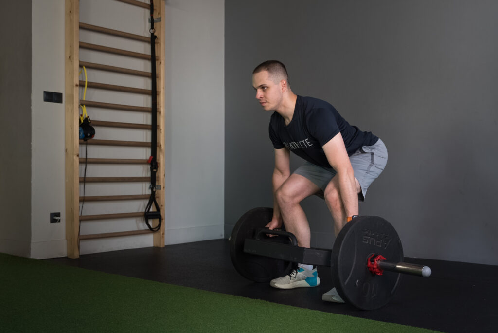 Mężczyzna wykonujący martwy ciąg podczas indywidualnego treningu siłowego