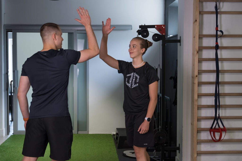 Trener personalny i podopieczny przybijający piątkę po treningu