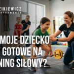 Dziecko wykonuje ćwiczenie siłowe pod okiem trenera przygotowania motorycznego